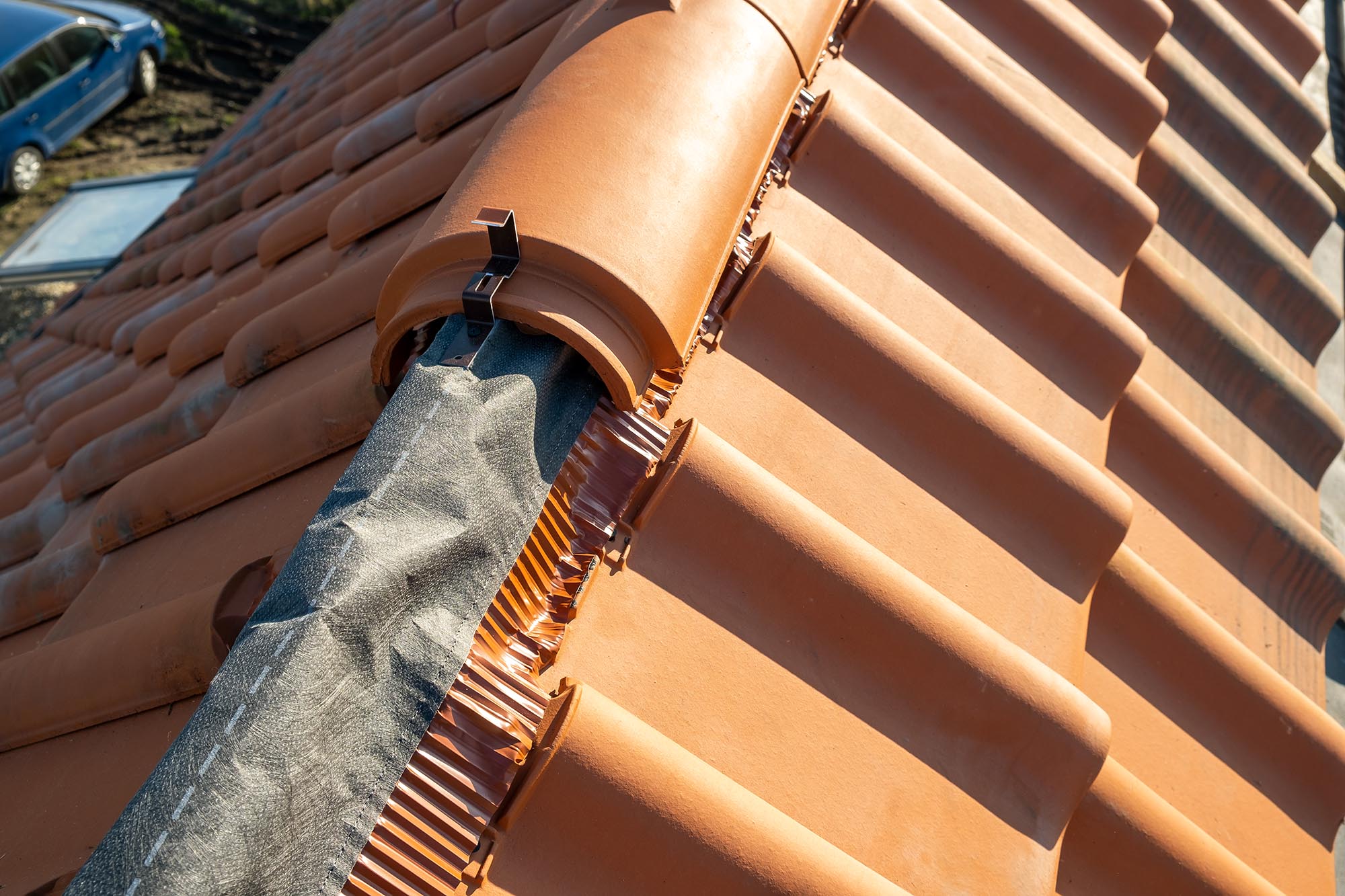 Closeup of yellow ceramic roofing ridge tiles on top of resident